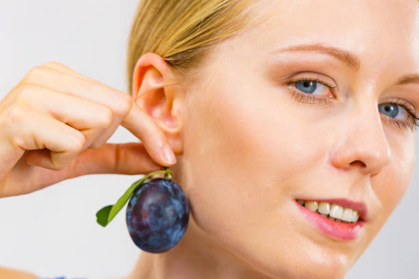 Close-up of woman putting on non-allergenic fake earrings
