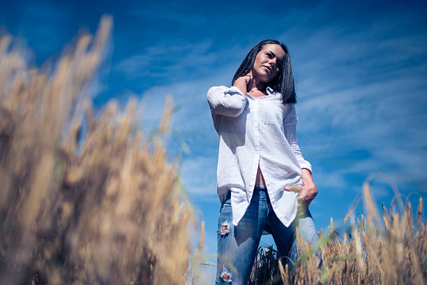 Stylish woman wearing an oversized shirt with distressed jeans